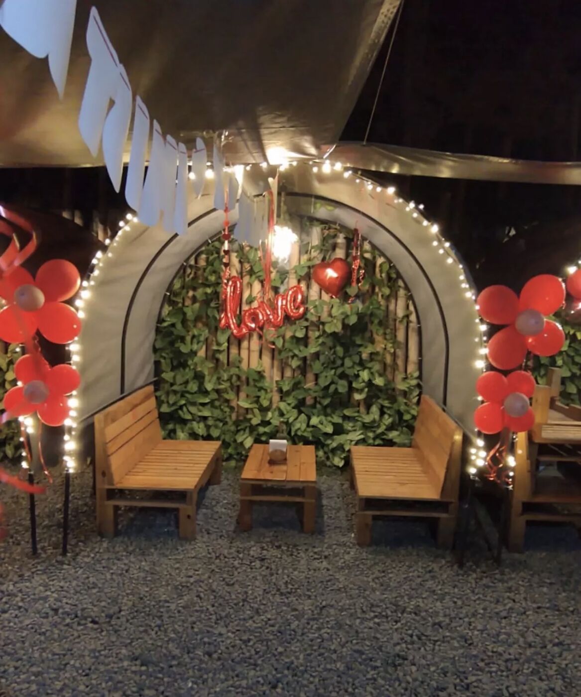 Domo con luces, globos en forma de flor y letrero love para aniversario
